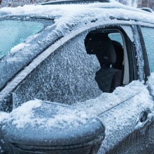 frozen car after snowstorm with broken window