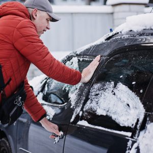 Frozen car door. Automobile car door or lock is frozen shut. Man driver trying to open frozen car