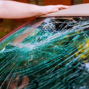 Glass broken cracks splinters in front of car front window.